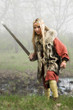 Viking girl  with sword in a fog wood