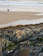 Solitary couple walking along stunning beach during vibrant suns