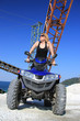 Frau auf dem Quad im Steinbruch vor alten Maschinen