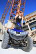 Frau auf dem Quad ATV im Steinbruch vor alten Maschinen