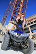 Frau auf dem Quad ATV im Steinbruch vor alten Maschinen