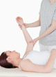 Portait of a sportswoman having her arm stretched by a masseuse