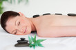 Young woman with massage stones on her back eyes closed Young woman with massage stones on her back eyes closed