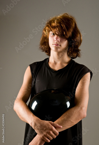 Foto: Young teen holding motorcycle helmet - a biker Young teen holding motorcycle helmet - a biker