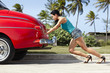 woman pushing broken down old car