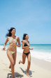 Foto: latina sisters in bikini on beach near caribbean sea latina sisters in bikini on beach near caribbean sea