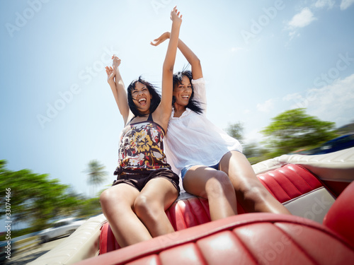 Foto: beautiful twin sisters having fun in cabriolet car beautiful twin sisters having fun in cabriolet car