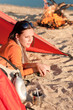Camping happy woman relax in tent by campfire
