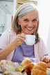 Glückliche Seniorin beim Früstück