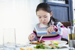 little girl appears unhappy while having a big breakfast