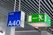 Green emergency exit sign,and blue gate sign in airport