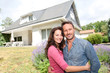 Foto: Happy couple standing in front of new home Happy couple standing in front of new home