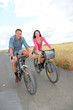 Couple riding bicycle on country road