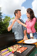 Foto: Happy couple cooking meat on barbecue grill Happy couple cooking meat on barbecue grill