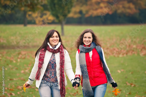 Photo: Two pretty girls having fun in a park Two pretty girls having fun in a park
