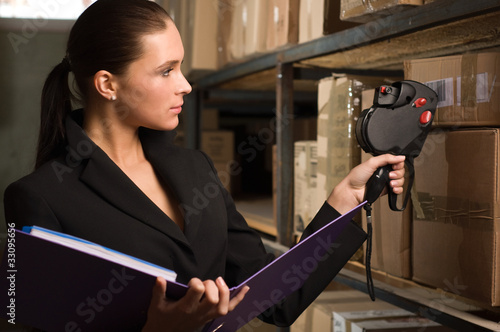 Photo: Business woman stock counting in warehouse Business woman stock counting in warehouse