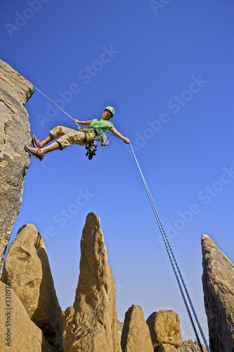 Photo: Rock climber rappelling. Rock climber rappelling.