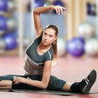 Photo: Woman doing stretching fitness exercise at sport gym. Yoga Woman doing stretching fitness exercise at sport gym. Yoga
