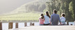 Family sitting on dock by lake