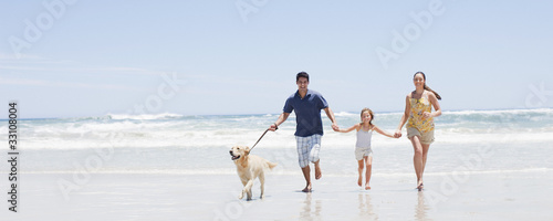 Photo: Family with dog running on beach Family with dog running on beach