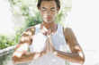 Man standing with hands clasped and eyes closed