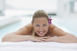 Woman laying on massage table at poolside