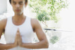 Man with eyes closed and hands clasped on patio