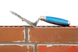 Foto: Trowel on new brick wall isolated on white Trowel on new brick wall isolated on white