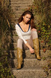 Young beautiful girl sitting on ancient stairs