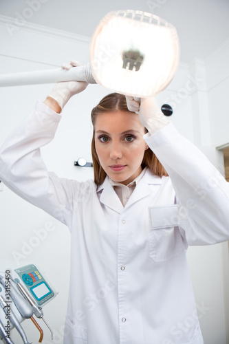 Photo: Dentist standing at lamp in dentist's office Dentist standing at lamp in dentist's office