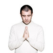 Man praying with hands clasped and eyes closed