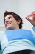 Boy in dentist's chair holding false teeth