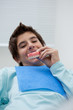Boy in dentist's chair holding false teeth