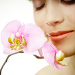 close up of a woman's face with an orchid