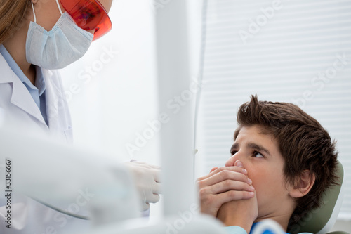 Photo: Boy in dentist's chair refusing treatment Boy in dentist's chair refusing treatment