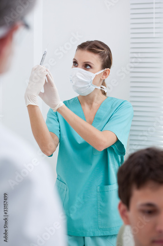 Photo: Dentist's assistant holding syringe Dentist's assistant holding syringe