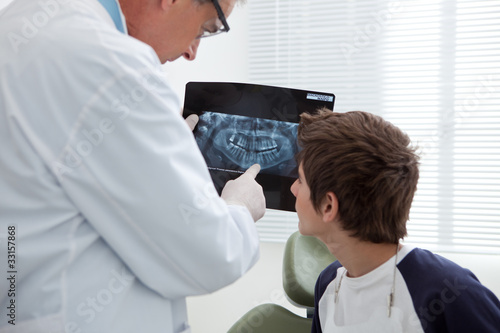 Foto: Dentist holding x-ray talking to boy Dentist holding x-ray talking to boy