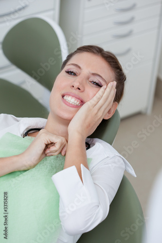 Photo: Woman having toothaches in dentist's chair Woman having toothaches in dentist's chair