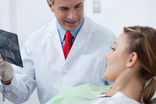 Photo: Dentist showing x-ray to woman Dentist showing x-ray to woman