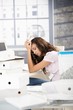Foto: Young girl having headache in office Young girl having headache in office