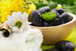 Spa,  flower on the towel, and a bowl with black stones