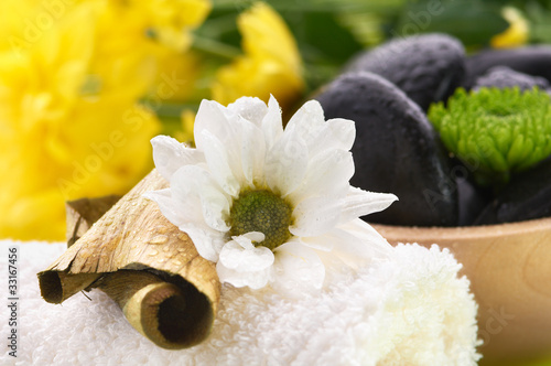 Photo: Spa, flower on the towel, and a bowl with black stones Spa, flower on the towel, and a bowl with black stones