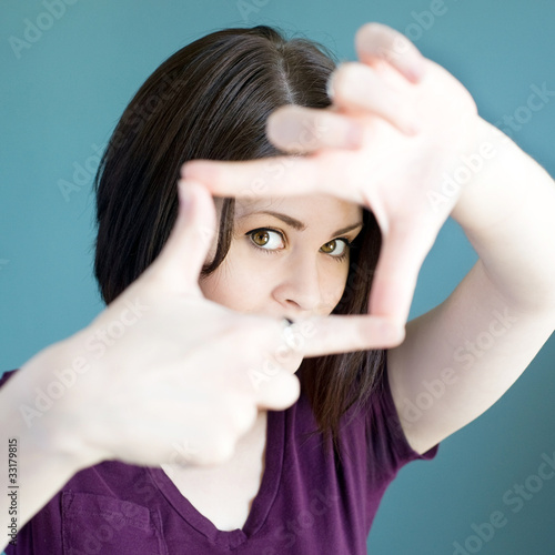 Photo: Woman making finger frame around her face Woman making finger frame around her face