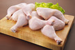Fresh raw chicken legs arrangement on kitchen cutting board