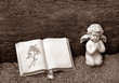 Engelsskulptur und Buch auf Friedhof