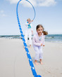 Family playing with skipping rope at the beach