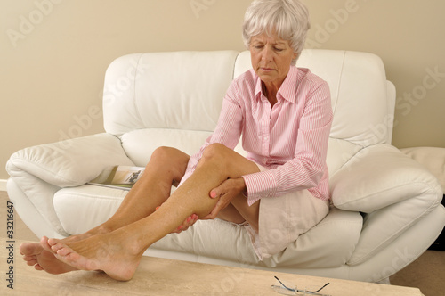 Photo: Seniorin massiert ihre Beine Seniorin massiert ihre Beine
