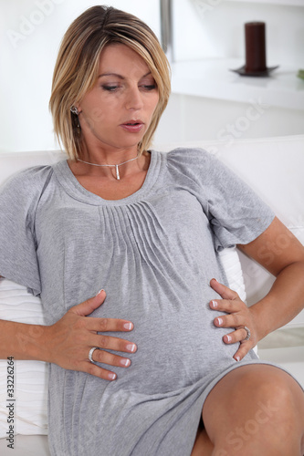 Photo: Woman holding her very pregnant stomach Woman holding her very pregnant stomach