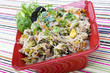 Pancit in a red ceramic dish