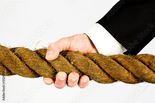 Photo: businessman hand gripping rope businessman hand gripping rope